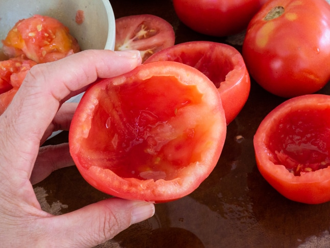 מרוקנים את העגבניות לפני המילוי ושומרים את התוכן בקערה